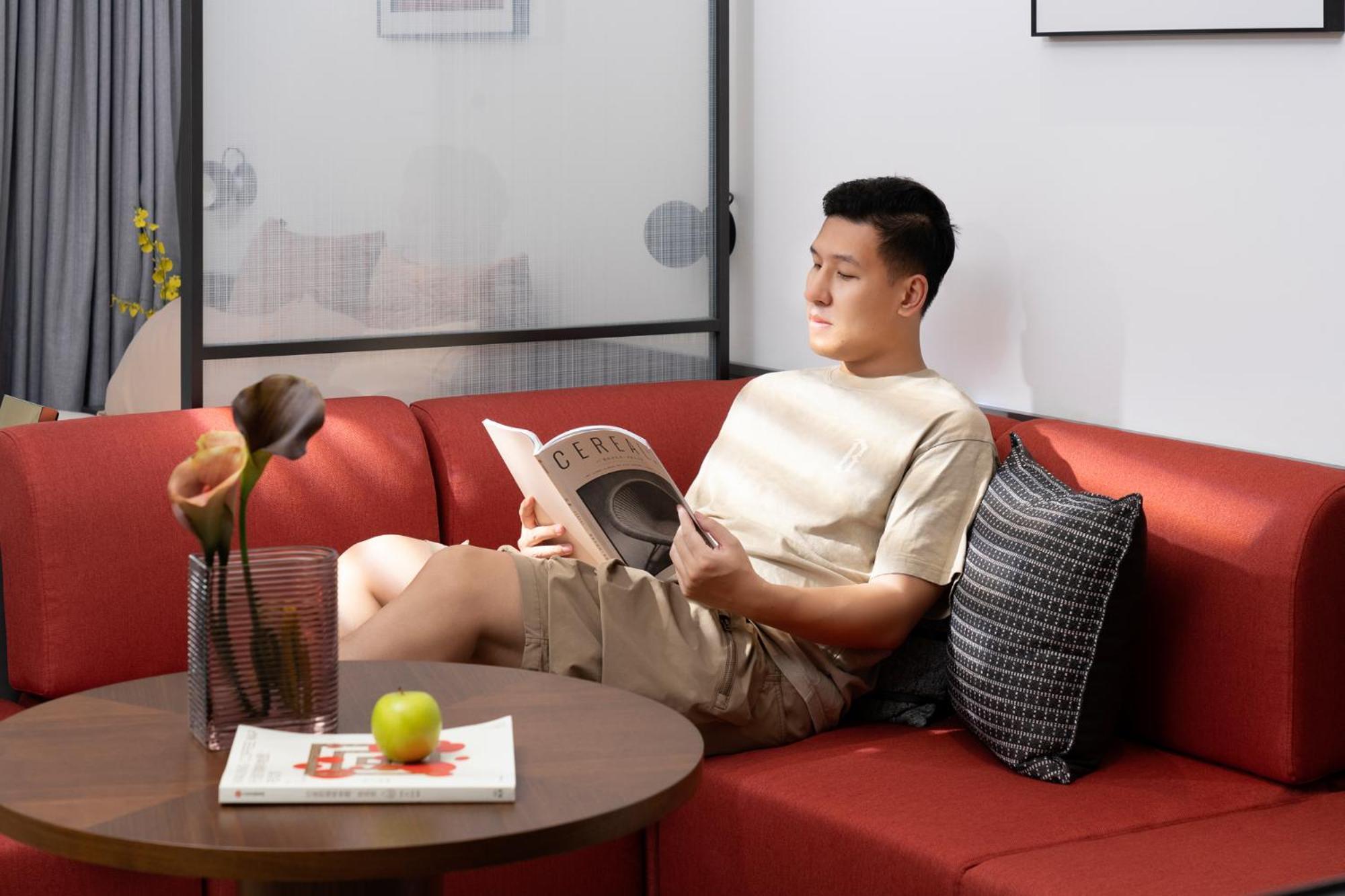 Base-Beijing Wangfujing Serviced Apartment- In Hutong &Bike Rental &Close To Forbidden City, Tian'Anmen Square &Subway Nearby &Free Coffee &Washing Machine,Kitchen &Restaurant Discount &English Speaking &High Speed Free Wifi Kültér fotó A man reading a book on a sofa